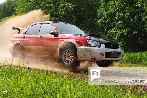 Rally car racing on dirt track