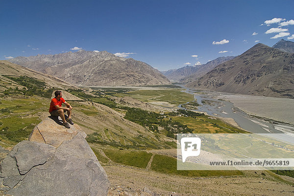 Mann genießt den Ausblick auf Berglandschaft von Langar  Wakhan Korridor  Tadschikistan  Zentralasien  Asien