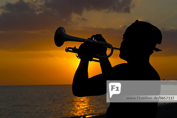 Mann spielt die Trompete bei Sonnenuntergang  Silhouette  Trinidad  Kuba  Karibik  Nordamerika