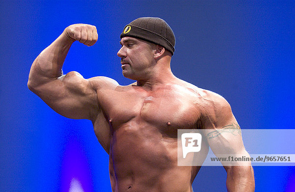 Bodybuilder zeigt seine Muskeln auf der Fitnessmesse FIBO in Essen