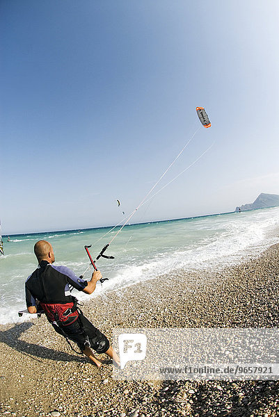 Kitesurfer  ascending sport kite (stunt kite)  Mediterranean coast  Spain  Europe
