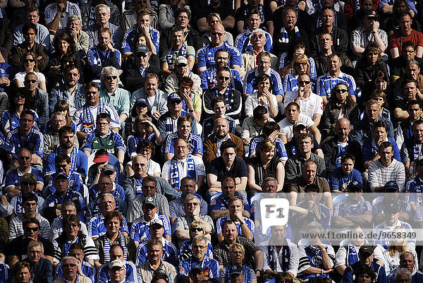 Skeptical Schalker fans at a first division German professional soccer match between Schalke 04 and Hanover 96 with a score of 1:1