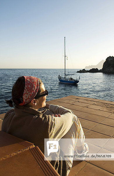 Woman looking at sailboat in a bay on the Mediterranean coast near Altea  Costa Blanca  Spain  Europe