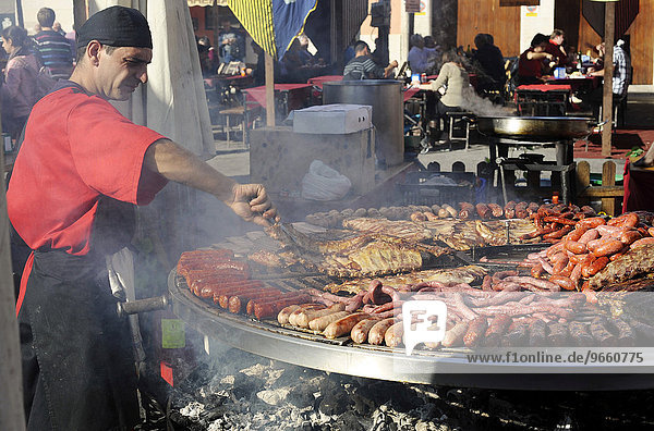 Koch an einem riesigen Grill auf dem jährlich stattfindenden Allerheiligenmarkt Fira de tots Sants Cocentaina Provinz Alicante Spanien Europa