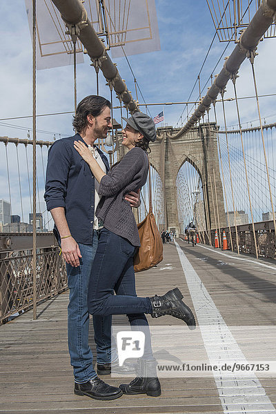 Happy couple embracing on Brooklyn Bridge