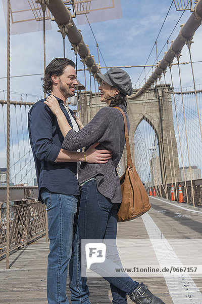 Happy couple embracing on Brooklyn Bridge