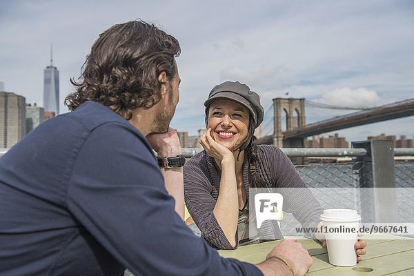 Happy couple sitting and discussing with cityscape in background