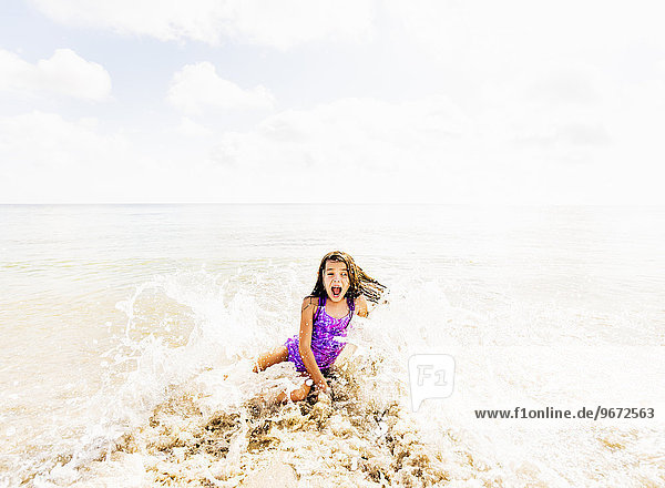Girl (6-7) having fun in water