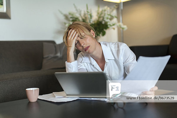 Portrait of overworked woman using computer