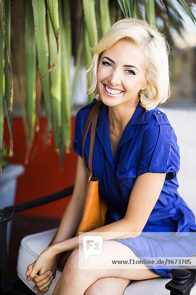 Woman with dyed hair sitting and smiling to camera