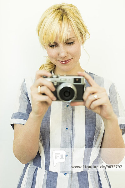 Studio shot of woman holding camera