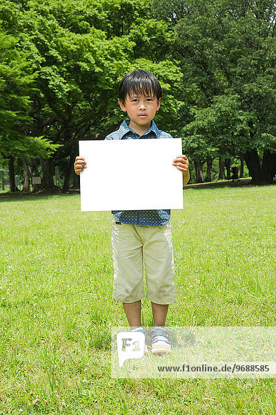 Japanese kid with whiteboard in a park