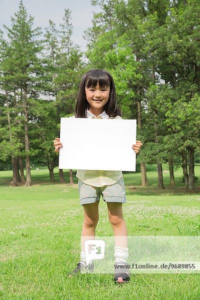 Japanese kid with whiteboard in a park