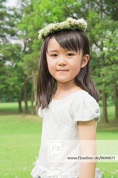 Japanese kid with flower tiara in a park