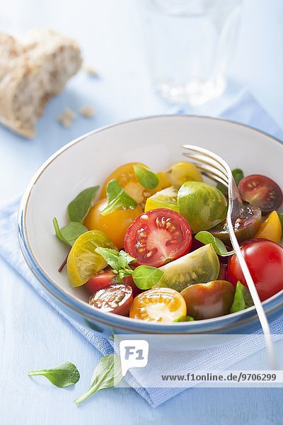 Bunter Tomatensalat mit Brotstück und Basilikum