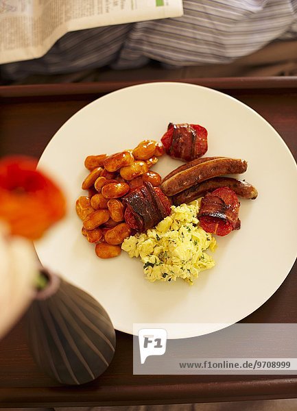 Englisches Frühstück mit Rührei  Baked Beans  Tomaten  Bacon und Bratwürstchen