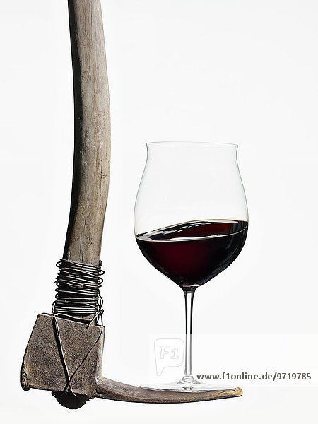 Rotweinglas balanciert auf einer Spitzhacke