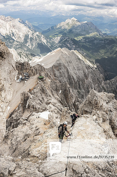 Female moutaineers on the Marino Bianchi Via Ferrata  below the Lorenzihütte refuge and the mountain station of the cable car  2932 m  at the back Mt Dürrenstein  2839 m  Cristallo group Ampezzo Dolomites  Cortina d'Ampezzo  Province of Belluno Dolomites  Alps  Veneto  Italy  Europe
