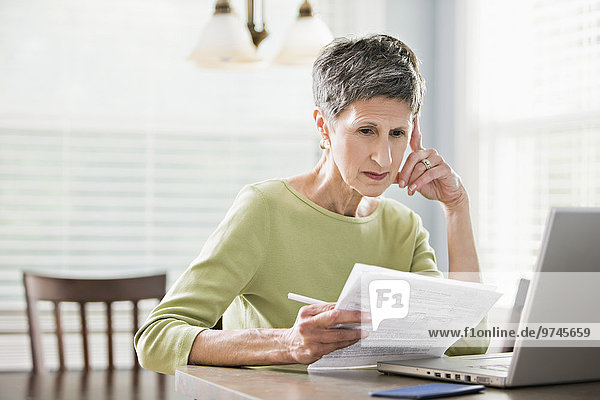Senior woman paying bills on laptop