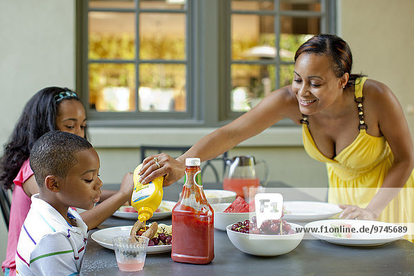 African American mother preparing lunch for children