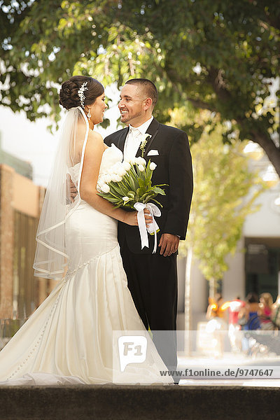 Smiling Hispanic bride and groom