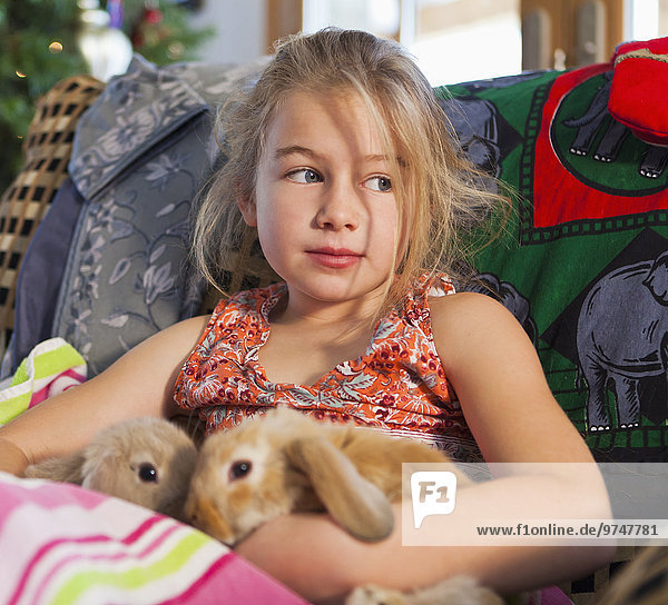 Europäer Couch halten Kaninchen Mädchen