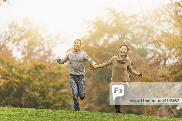Smiling couple running in park