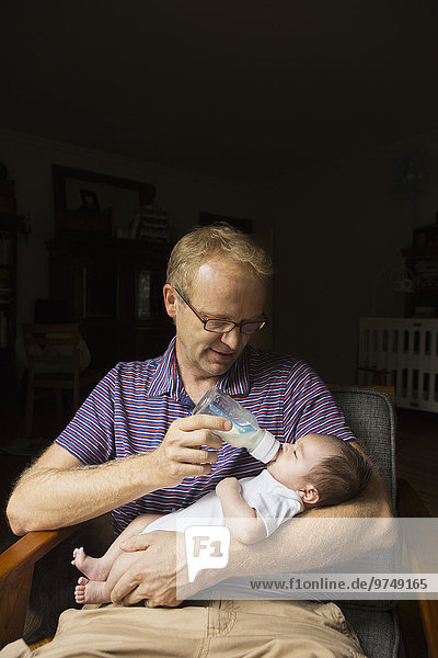 Menschlicher Vater Sessel Baby Flasche füttern