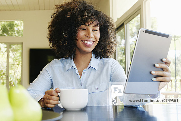 Mixed race businesswoman using digital tablet at table