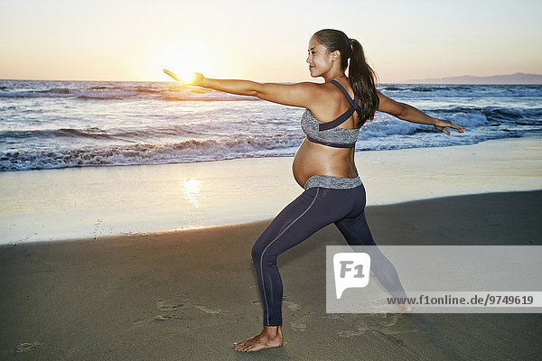 Frau Strand Hispanier üben Schwangerschaft Yoga