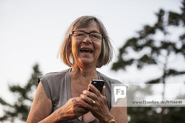 Portrait of happy senior woman with cell phone