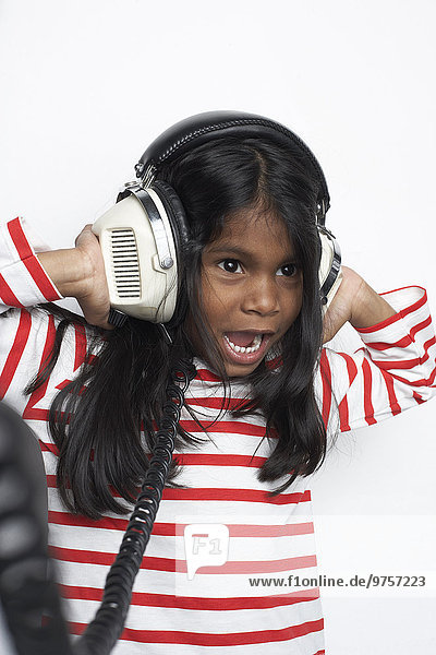 Porträt eines Mädchens  das laute Musik mit Kopfhörern hört.