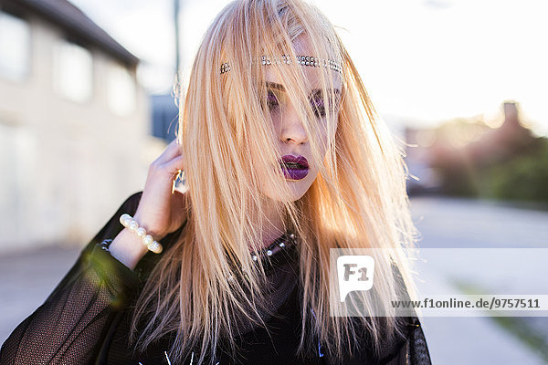 Portrait einer rouged blonden Frau mit Haarsträhnen im Gesicht