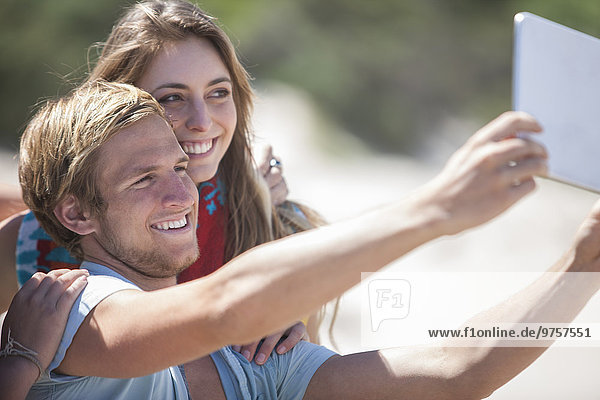 Freunde  die einen Selfie mit digitalem Tablett am Strand nehmen