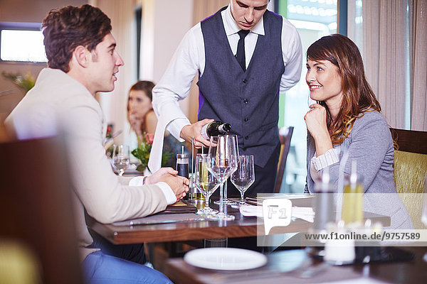 Kellnerin beim Weinschenken für Geschäftspartner im Hotelrestaurant