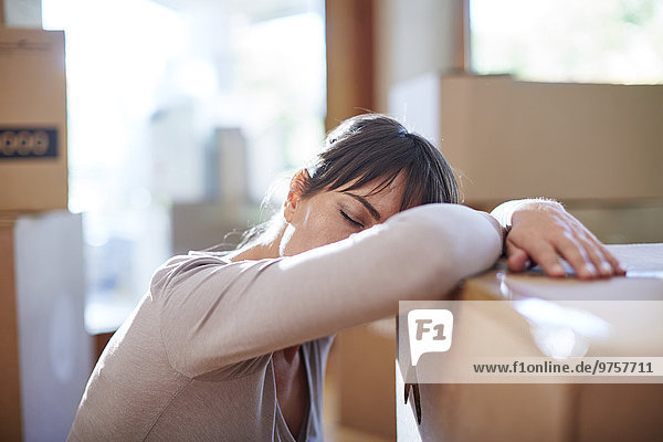 Woman moving house resting on a box