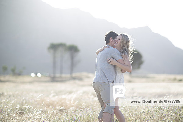South Africa  Young couple embracing in field