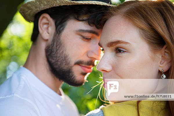 Ein junges Paar teilt sich einen intimen Moment im Freien.