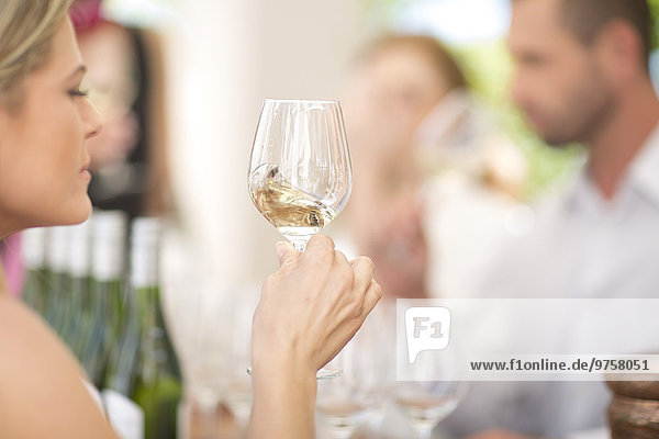 Woman examining white wine on a wine tasting session