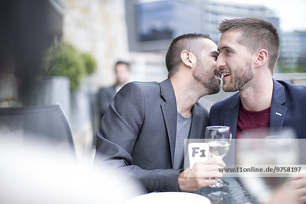 Schwules Paar trinkt Wein in einem Restaurant