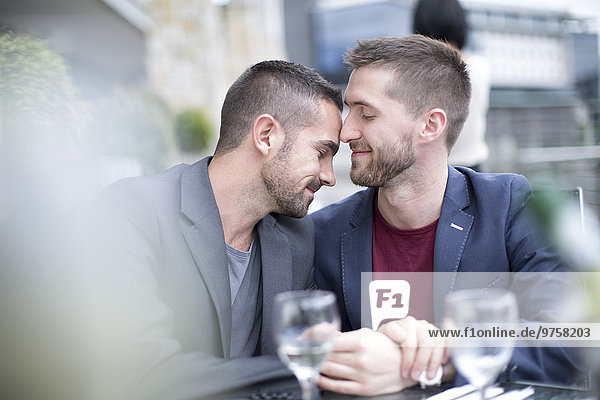 Schwules Paar  das einen intimen Moment in einem Restaurant verbringt