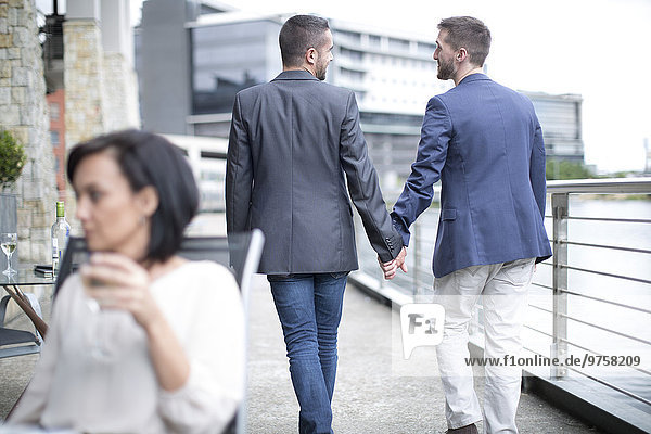 Gay couple walking together hand in hand