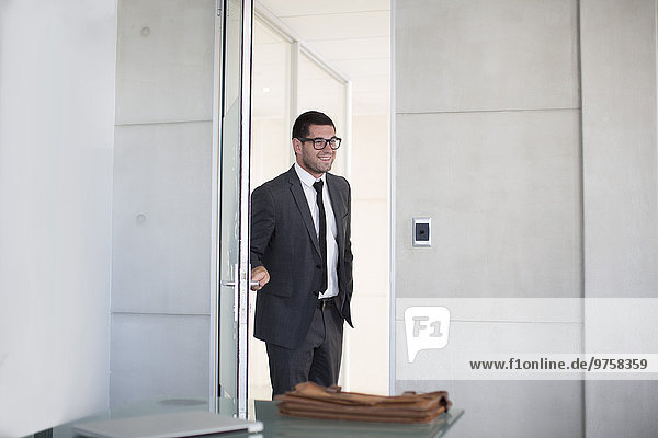 Businessman in suit opening boardroom door