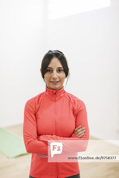 Porträt einer lächelnden jungen Frau in einem Trainingsanzug