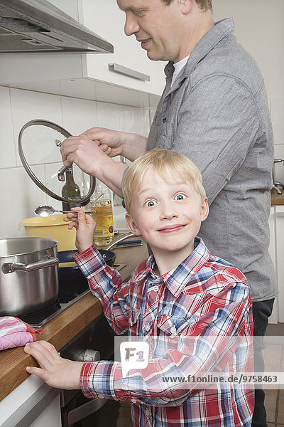 Portrait des Jungen beim Kochen mit seinem Vater