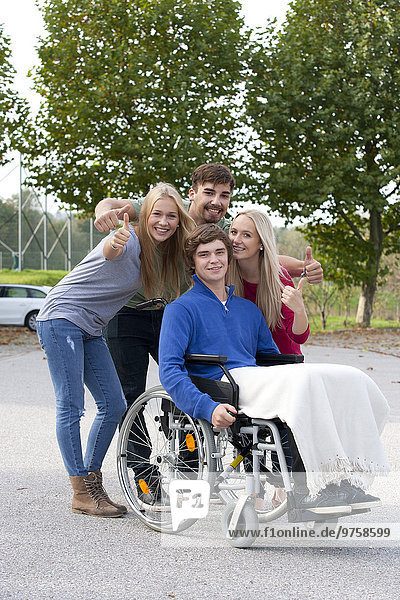 Young man in wheelchair with friends