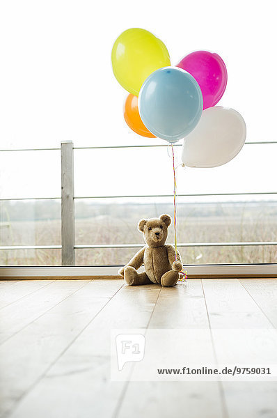 Luftballons und Teddybär am Fenster