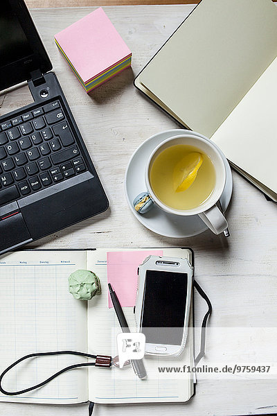 Kleines Heimbüro mit Handy  Laptop  Notebook  Kalender  Tee und Kekse