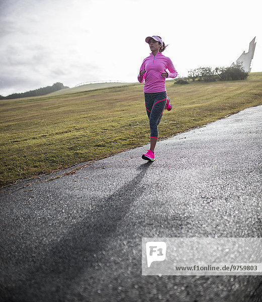 Spanien  Gijon  sportliche junge Frau beim Laufen auf dem Weg