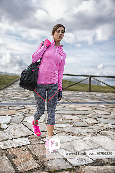 Spanien  Gijon  sportliche junge Frau beim Spaziergang im Freien